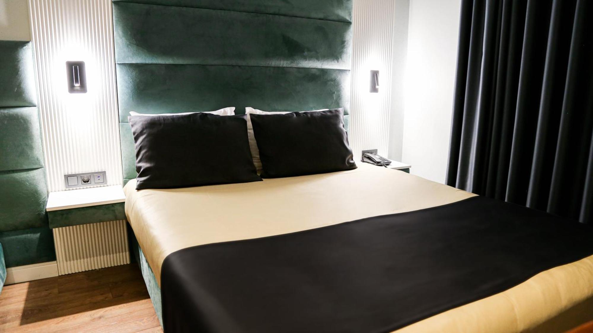 Axu Airport Hotel Arnavutkoy Eksteriør billede A bed with a bed runner